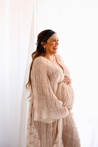 Pregnant woman leaning against a wall