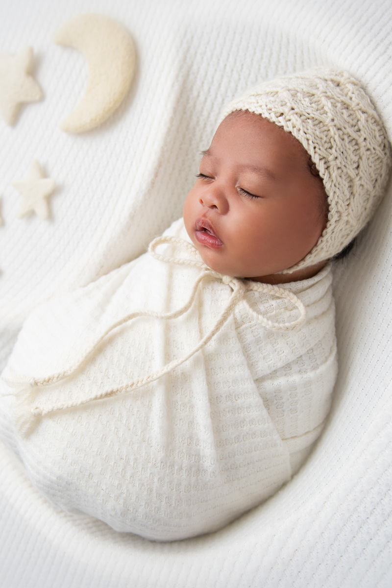 Newborn baby wrapped in soft neutral textiles