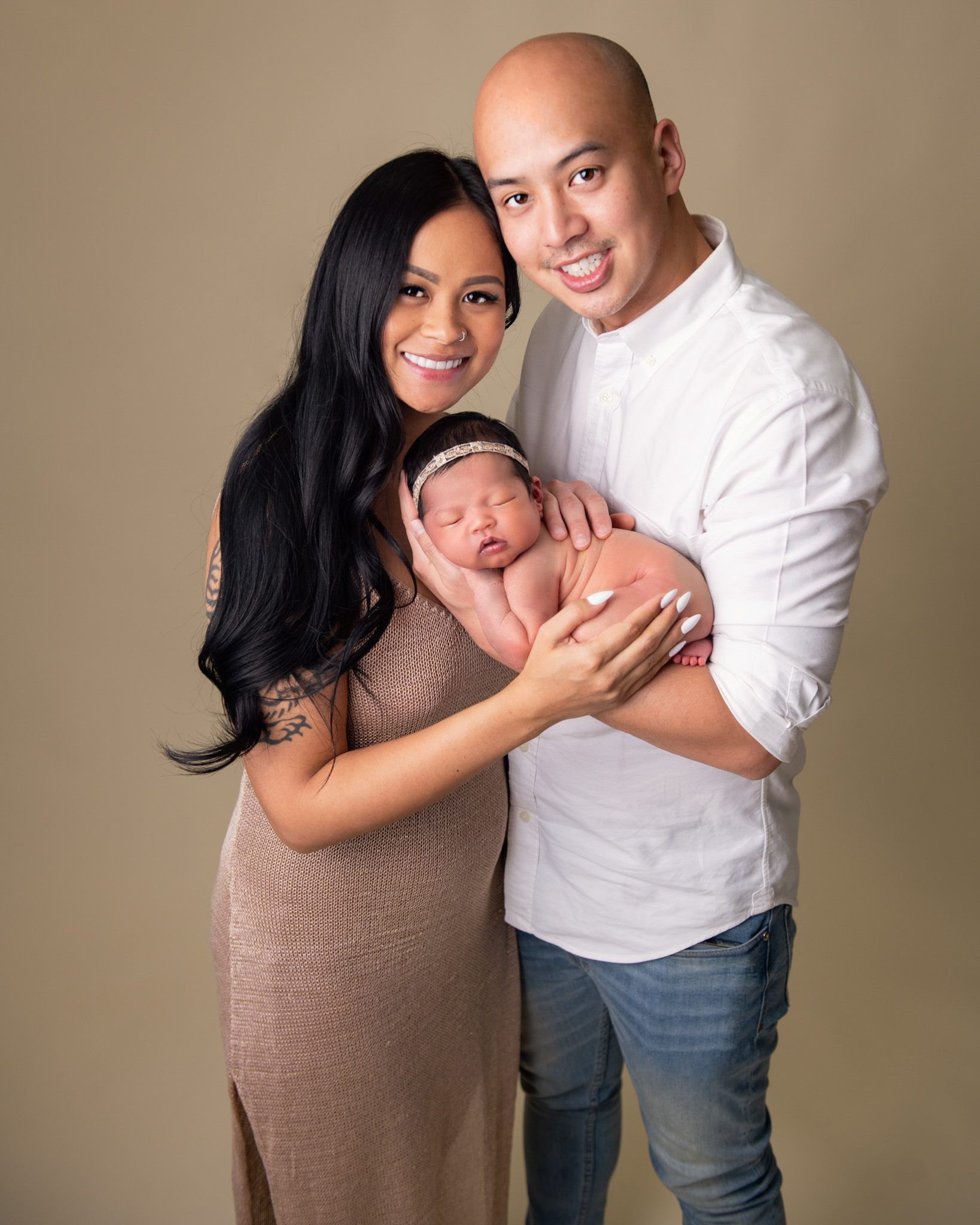 Mother and father holding a newborn baby during a photography session in Goodyear, AZ